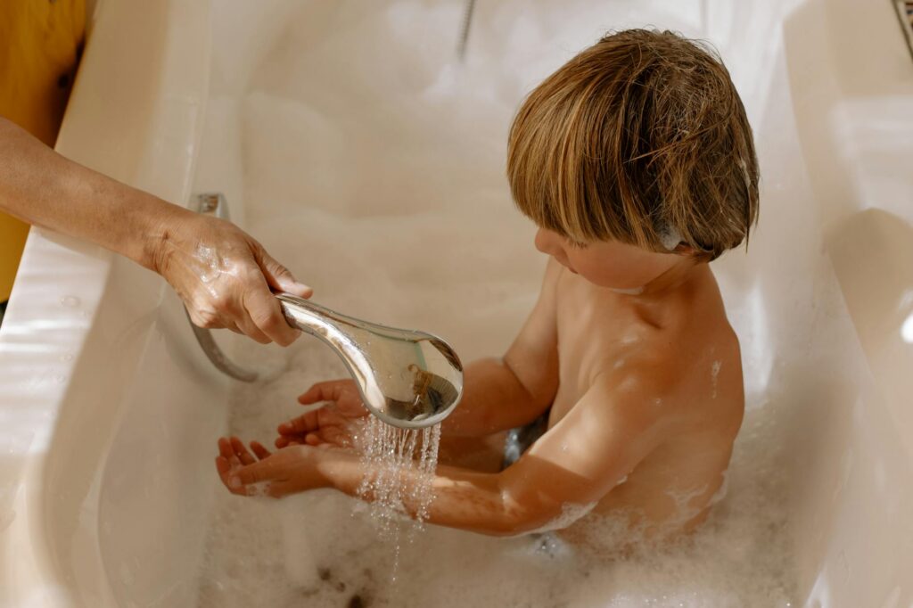 a boy taking a bath in a bathtub